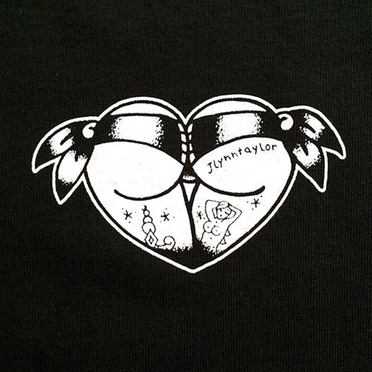 Tattoo style butt heart logo on black t-shirt close up.