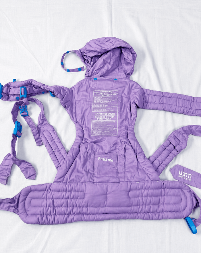 We Made Me Pao Papoose Three 3-in-1 Baby Carrier in Purple with multiple carrying positions, padded shoulder straps, adjustable waist belt, ergonomic support, and breathable fabric for comfortable babywearing.